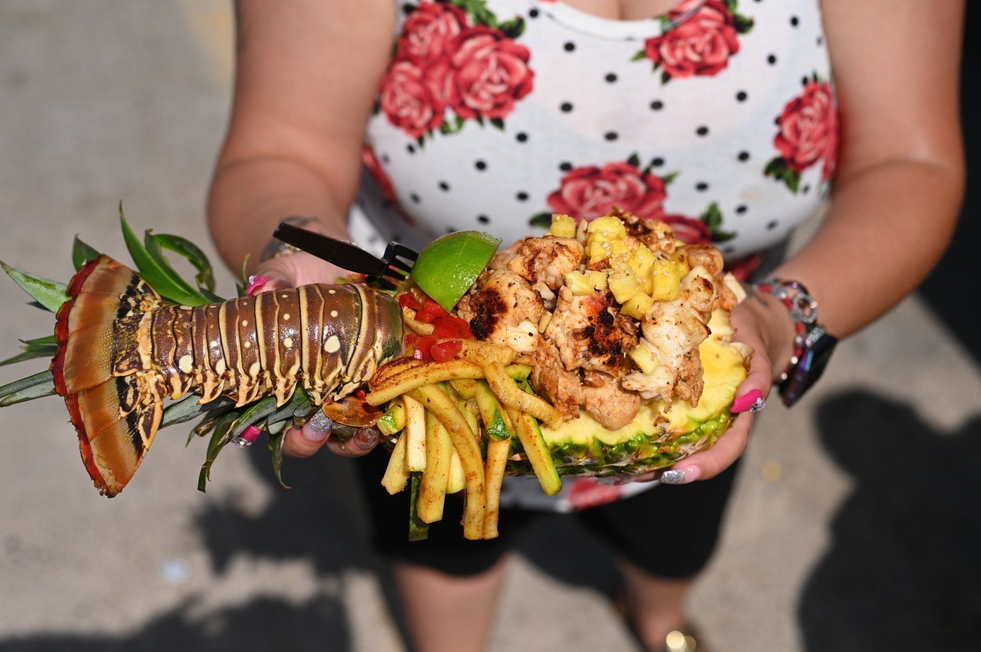 Gulf lobster and shrimp piled into a fresh-carved pineapple boat with mango pico and fries