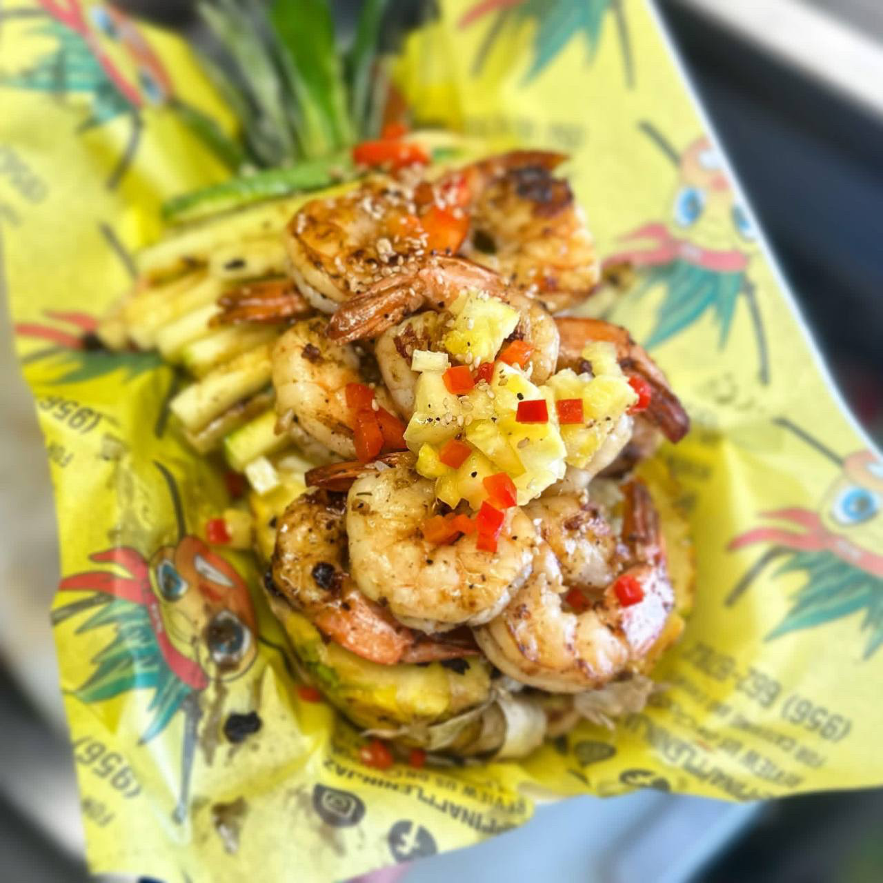 Close-up of the grilled shrimp Island Bowl on the branded Pineapple Ninjaz parrot wrapper